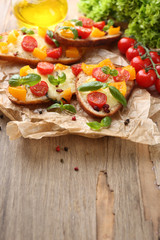 Tasty bruschetta with tomatoes, on old wooden table