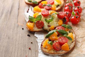 Tasty bruschetta with tomatoes, on old wooden table
