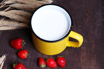 Ripe sweet strawberries, fresh bun and mug with milk