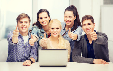 smiling students with laptop showing thumbs up