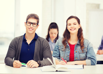 Fototapeta premium two teenagers with notebooks and book at school