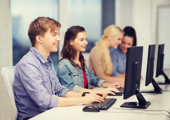 students looking at computer monitor at school