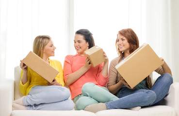 smiling teenage girls with cardboard boxes at home