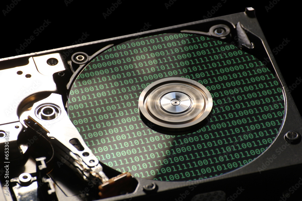 Fototapete ard disk on a black background with reflections of binary code