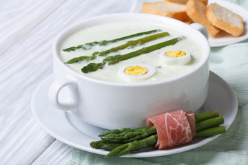 Asparagus soup with eggs in white bowl