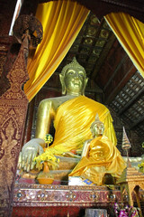 Obraz premium Buddha statue with yellow curtains