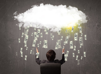 Business man in suit looking at cloud with falling money