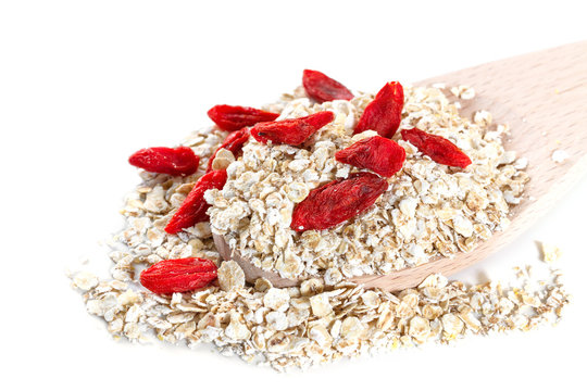 Oat flakes with goji berries on white background
