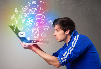 Casual man holding laptop with colorful hand drawn multimedia sy