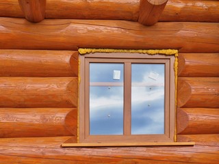 Detail of beams in cabin wall and wooden window. Painted wood