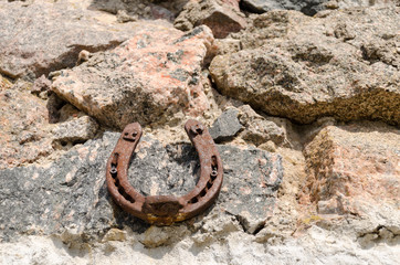 old iron fortune symbol horseshoe on stone wall