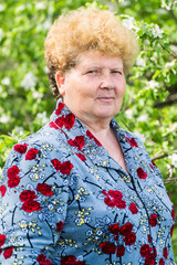 Elderly woman in a spring garden