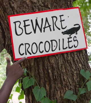Achtung Krokodile - Guide mit Schild in der Natur