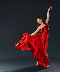 Naklejka premium beautiful ballerina dancing a long red dress flying
