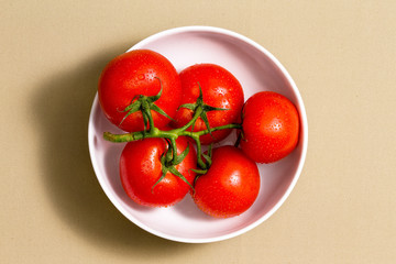 Bunch of ripe tomatoes in a bowl on a cotton cloth