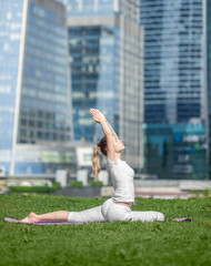 young beautiful woman makes exercise in the City
