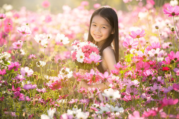 Naklejka premium Little asian girl in cosmos flower fields