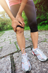 woman runner hold her sports injured knee