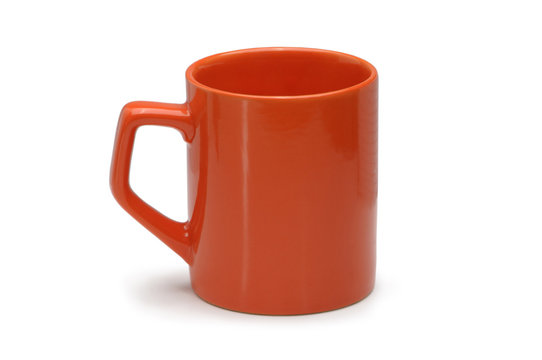 Orange ceramic mug isolated on white background.