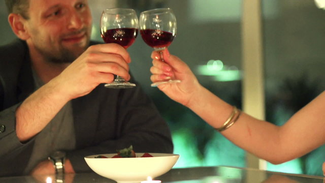 couple making a toast with glasses of wine during a romantic eve