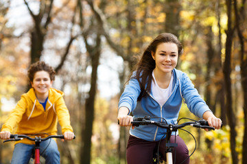 Fototapeta na wymiar Urban biking - teens riding bikes in city park