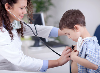 Young smiling friendly female doctor examining a little boy