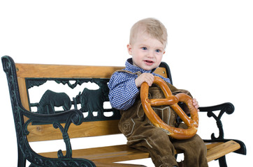 Lachender Junge mit Tracht und Riesenbreze