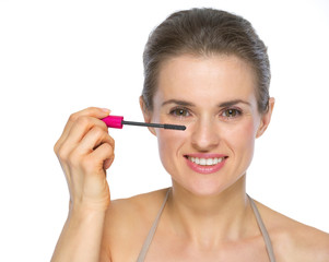 Fototapeta premium Happy young woman applying mascara