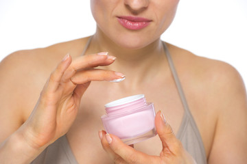 Closeup on young woman applying creme