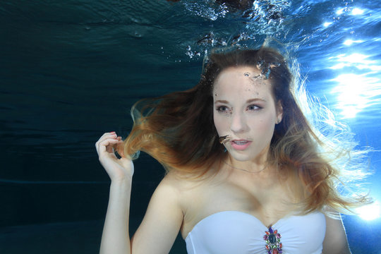 Young Woman Underwater Making Bubbles