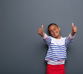 Little boy laughing with thumbs up sign