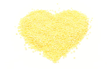 Heart shaped millet groats on white background