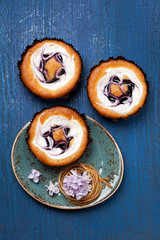 Cakes with berries and cream on blue background