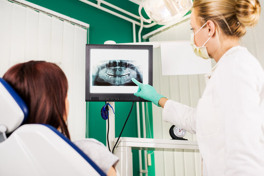 Dentist showing to the patient X-ray picture