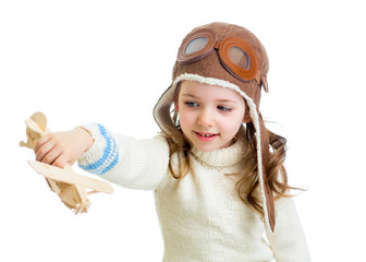 smiling child dressed pilot and playing with wooden airplane toy