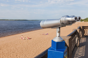 Naklejka premium Coin operated binocular on the bank of river in summertime
