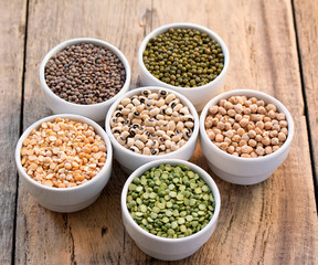 Six bowls with cereals on wooden desk