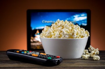 Popcorn and a remote control for the TV background - 65390675