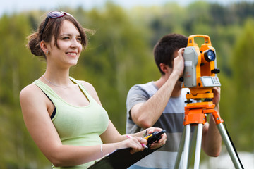 Two young land surveyors at work © lightpoet