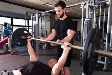 Gordijnen Bench press weightlifting man with personal trainer © lunamarina