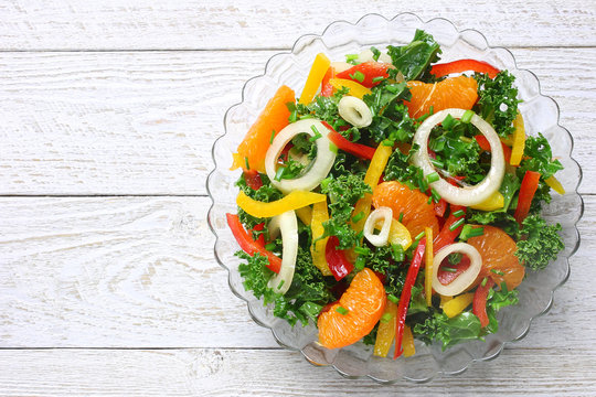 Salad with curly kale, paprika, mandarin and onions
