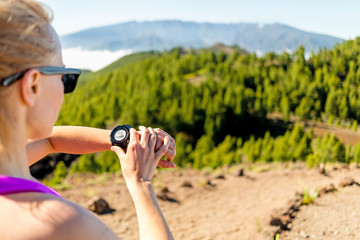 Cross country runner looking at sport watch - 65399883
