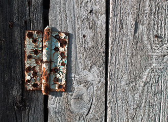 Old rusty metal door hinge on wooden door