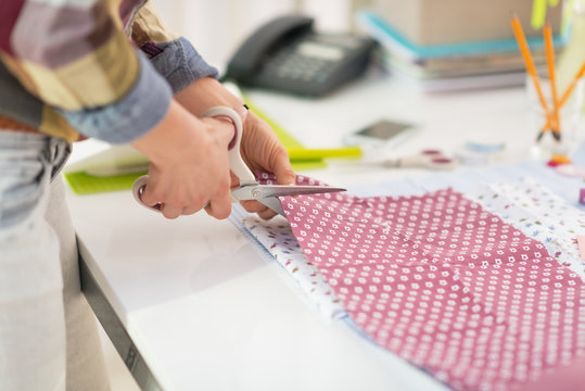 Closeup on seamstress cutting fabric