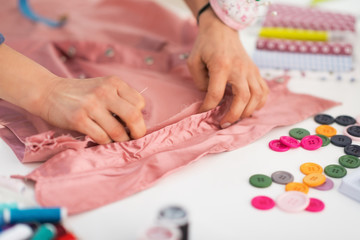 Obraz na płótnie Canvas Closeup on seamstress working with garment