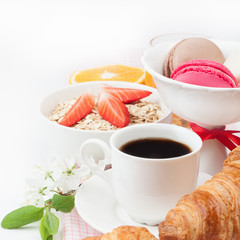 Coffee cup, croissant  and colourful french macaroons in vase  f