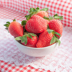 Small bowl filled with succulent juicy fresh ripe red strawberri