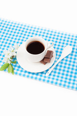 Coffee cup with chocolate and a sprig of cherry blossoms