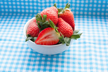Small bowl filled with succulent juicy fresh ripe red strawberri