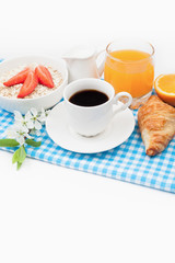 Coffee cup, croissant, oatmeal with strawberries, fruit juice, o